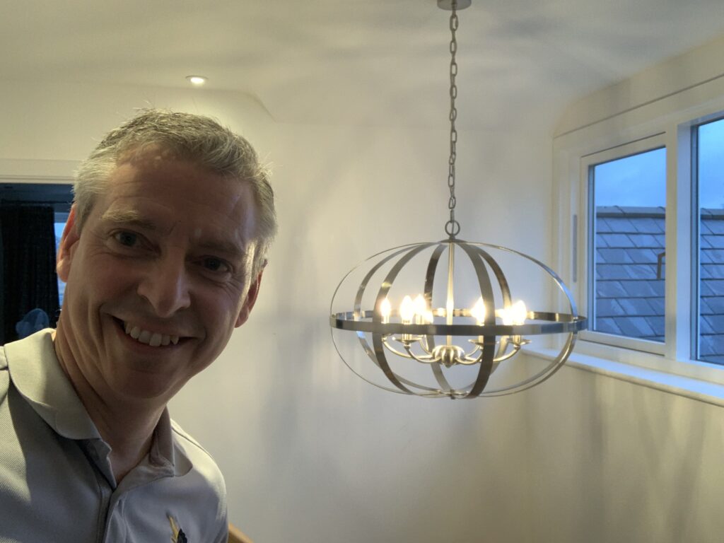 Jason Pope with a new ceiling light fitting he hung, the lighting work we do in Keyston and nearby