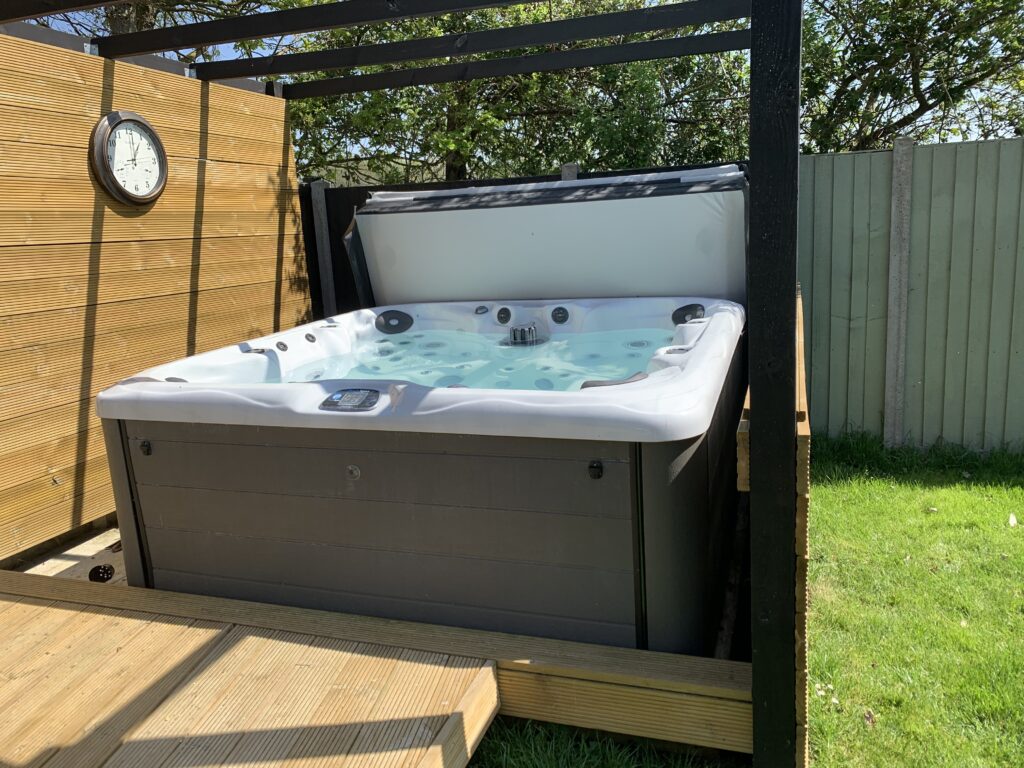 Hot tub on a timber deck in a Cambridgeshire garden, with its electrical supply fitted by Spaldwick Electrical