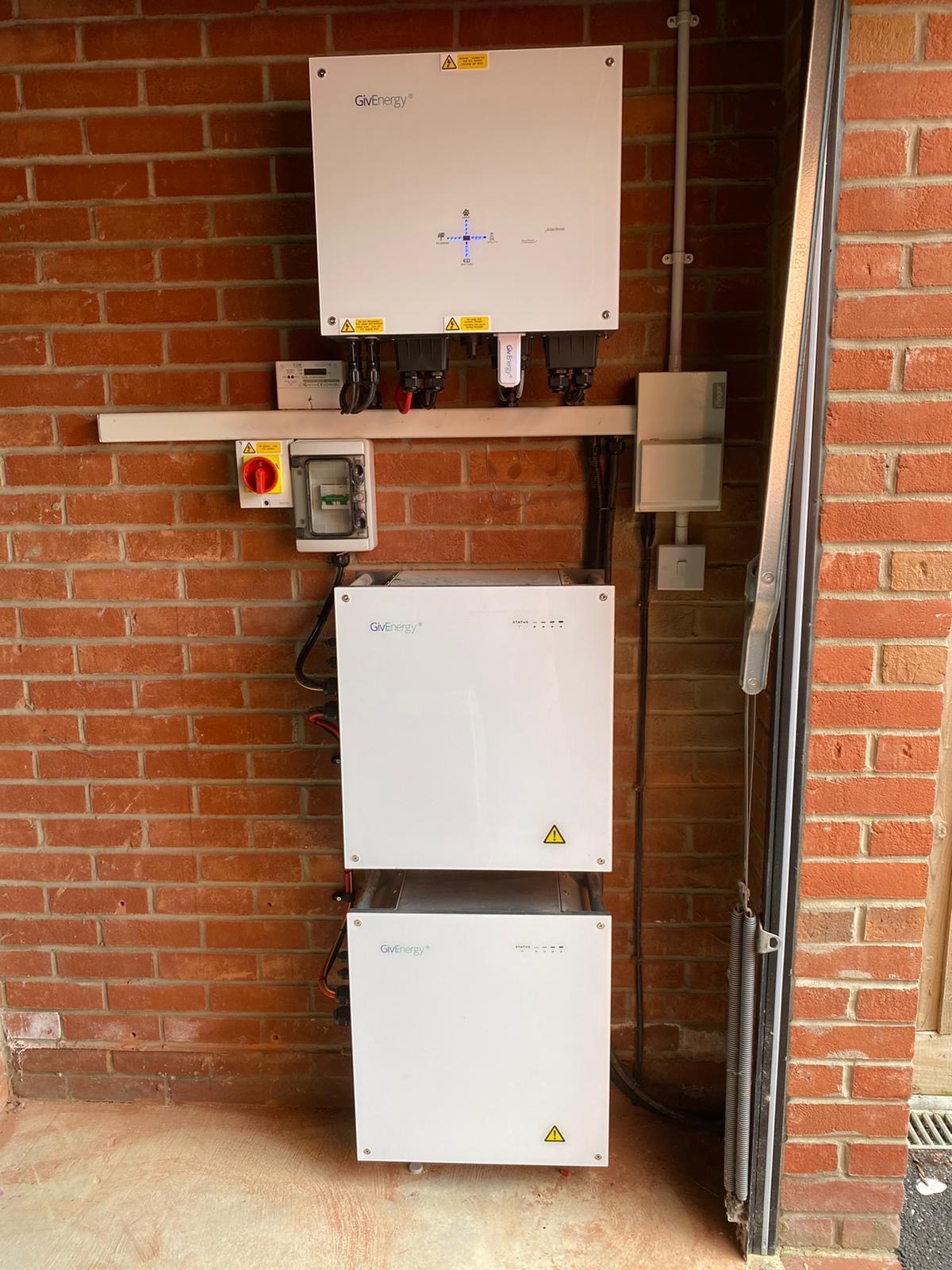 GivEnergy hybrid inverter and two batteries on a garage wall, the battery upgrade we offer near Molesworth