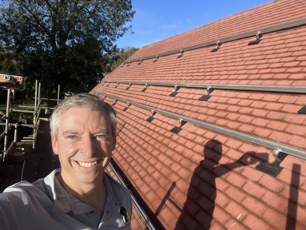 Jason Pope with the solar mounting rails fixed on the roof in Brampton, Cambridgeshire