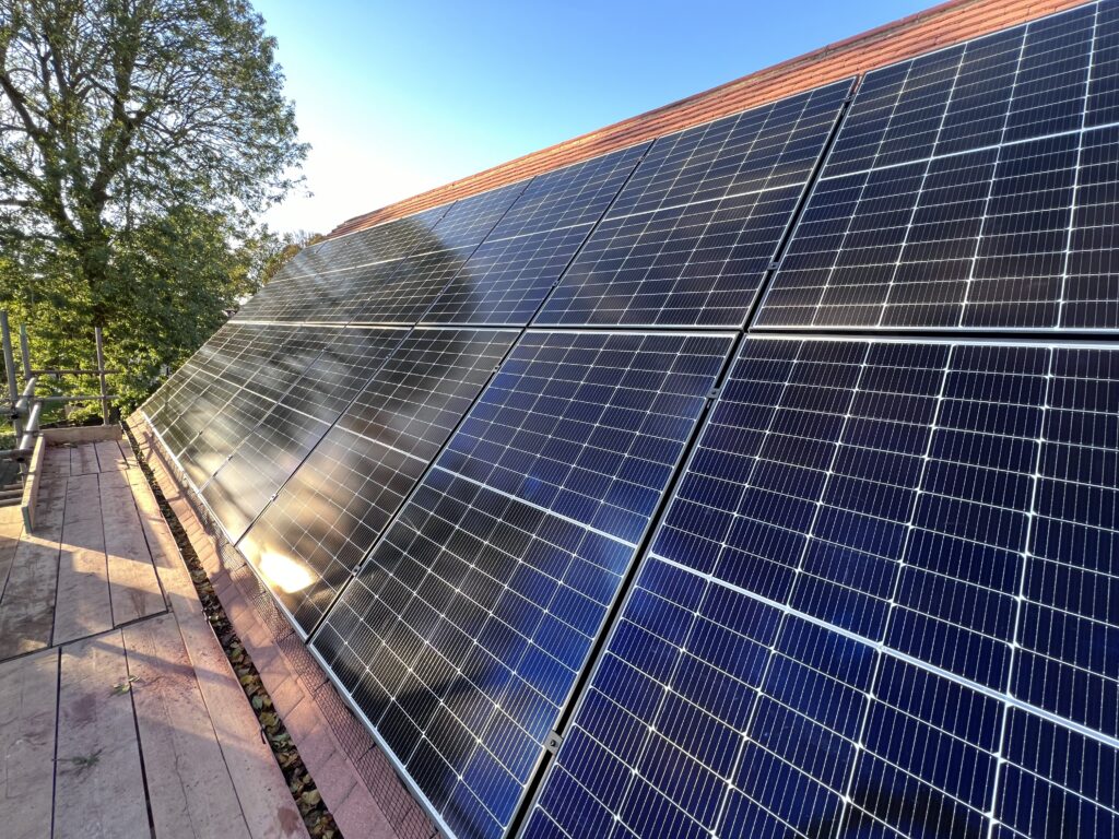 The finished 16 panel solar array on a tiled roof in Brampton, seen from the scaffold