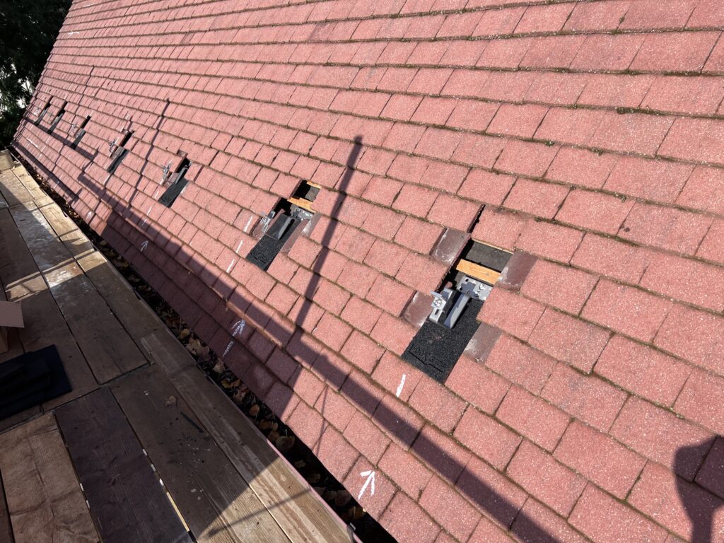 Hook stops fitted under the roof tiles ready for solar mounting rails on a house in Brampton