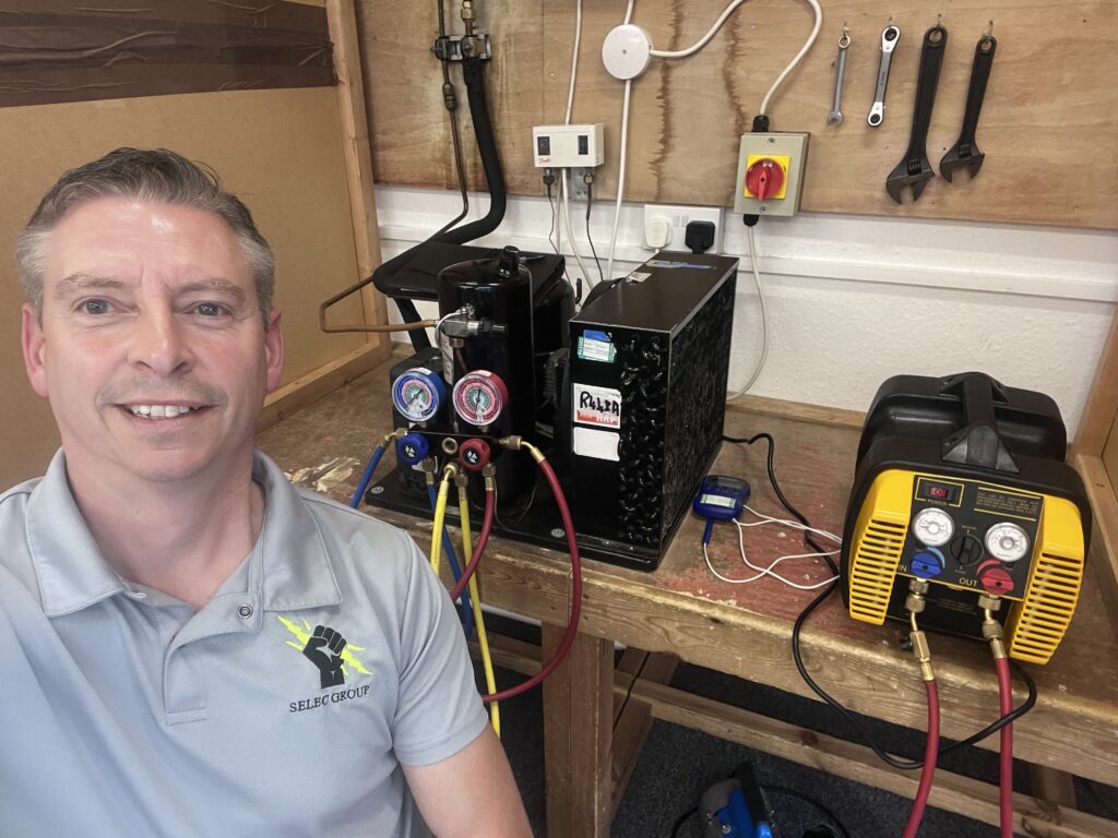 Jason Pope with the vacuum pump and gauges we use to commission air conditioning in Aldwincle homes