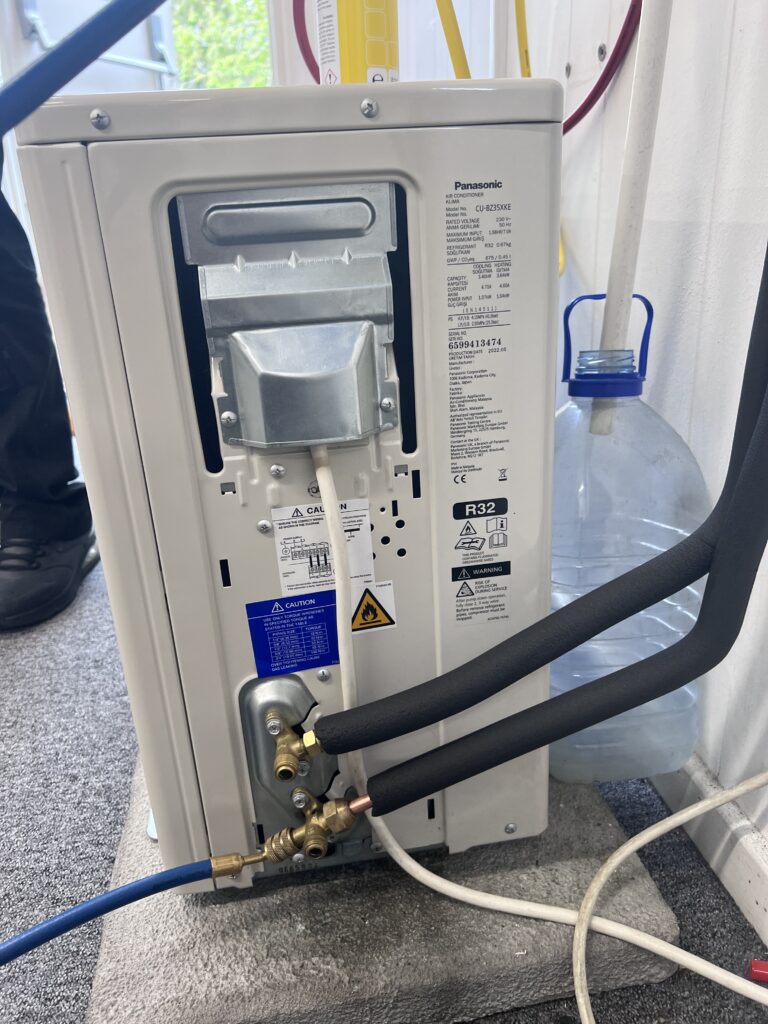 Air conditioning outdoor unit with insulated pipework connected, the kind of install we commission in Grafham