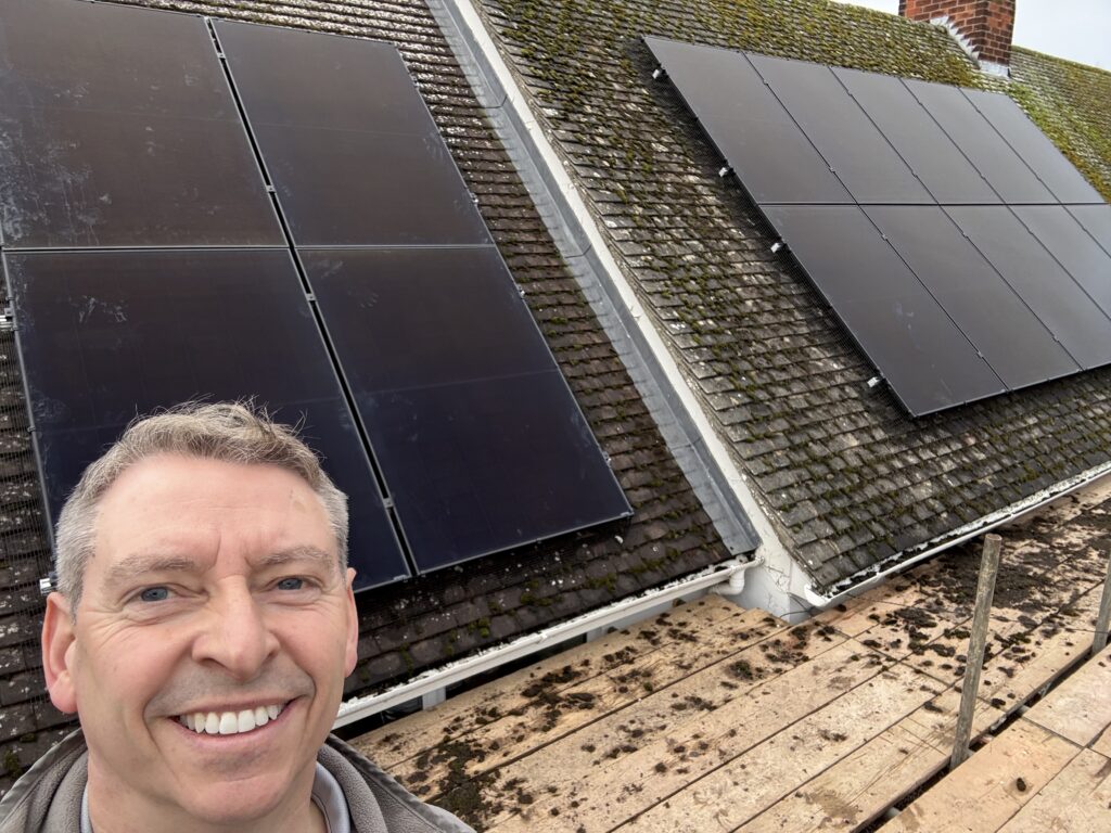 Jason Pope on a roof with newly installed solar panels