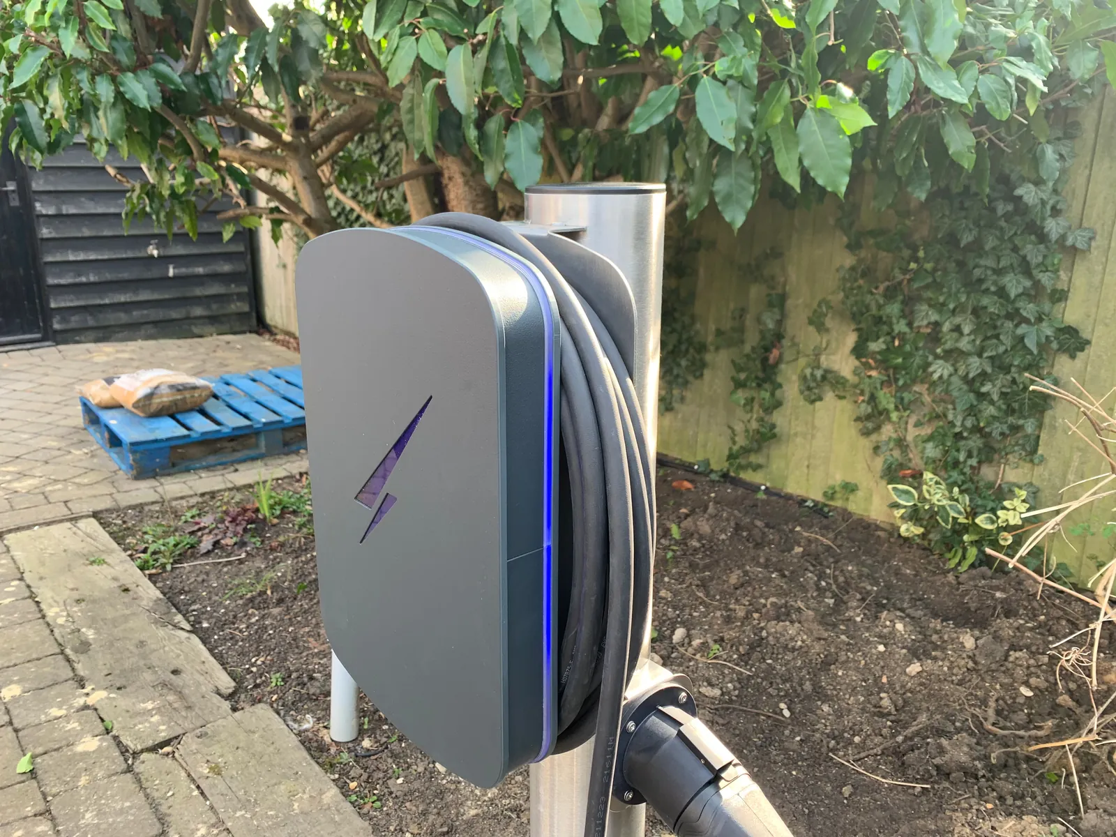 EV charger mounted on a post in a garden, installed by Selec Group