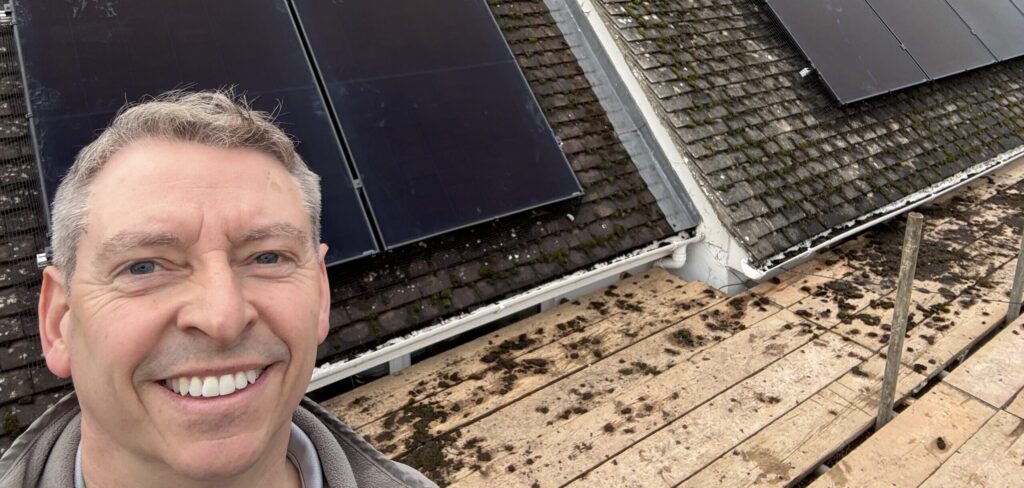 Jason Pope, owner of Selec Group, on a roof with solar panels installed in Cambridgeshire