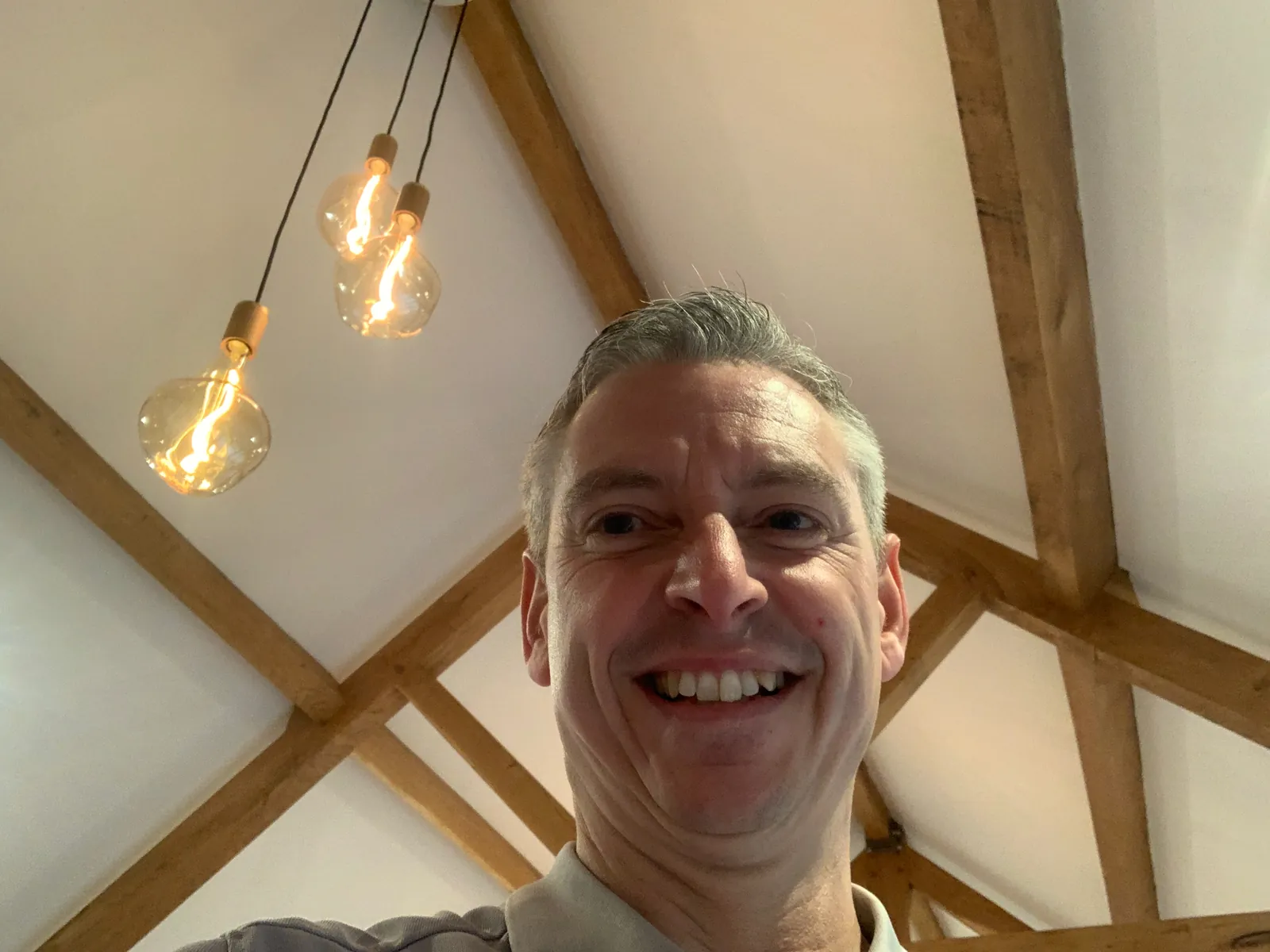 Jason Pope of Selec Group under new filament pendant lights in a vaulted room in Stow Longa