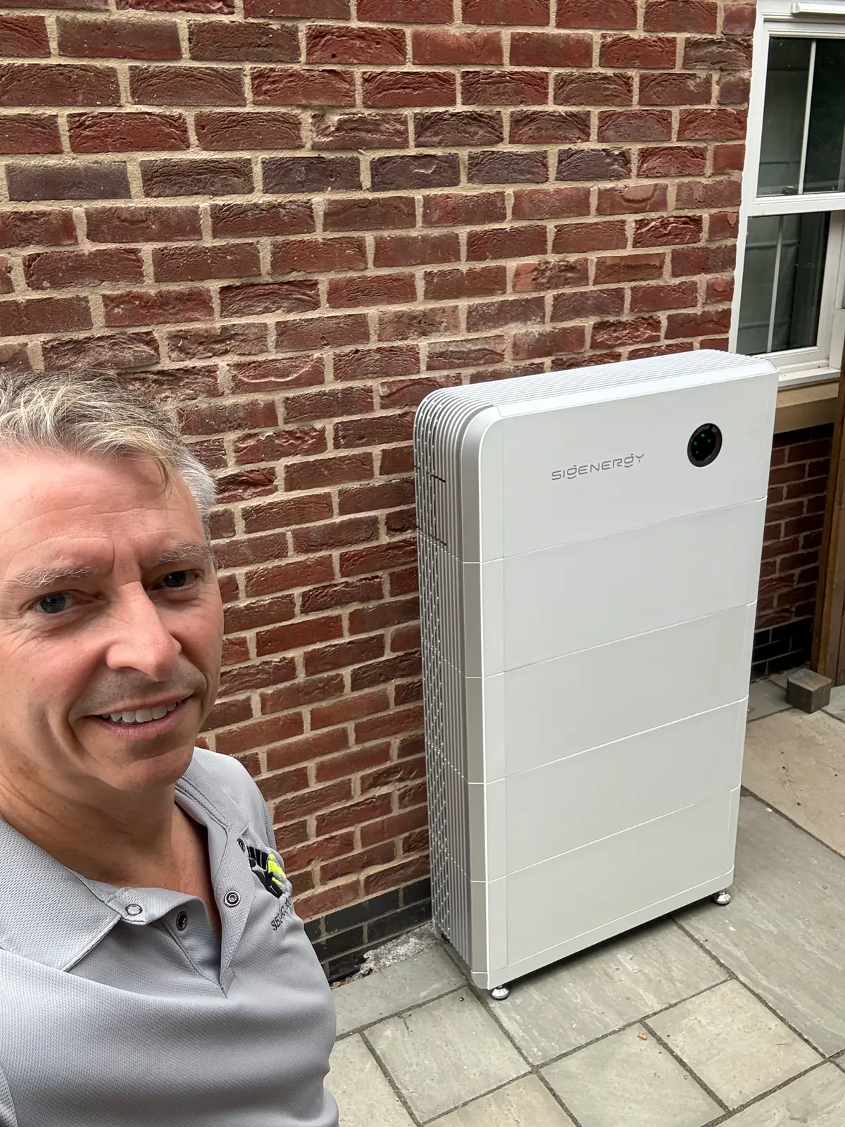 Jason Pope of Selec Group beside a newly installed home battery in Kimbolton