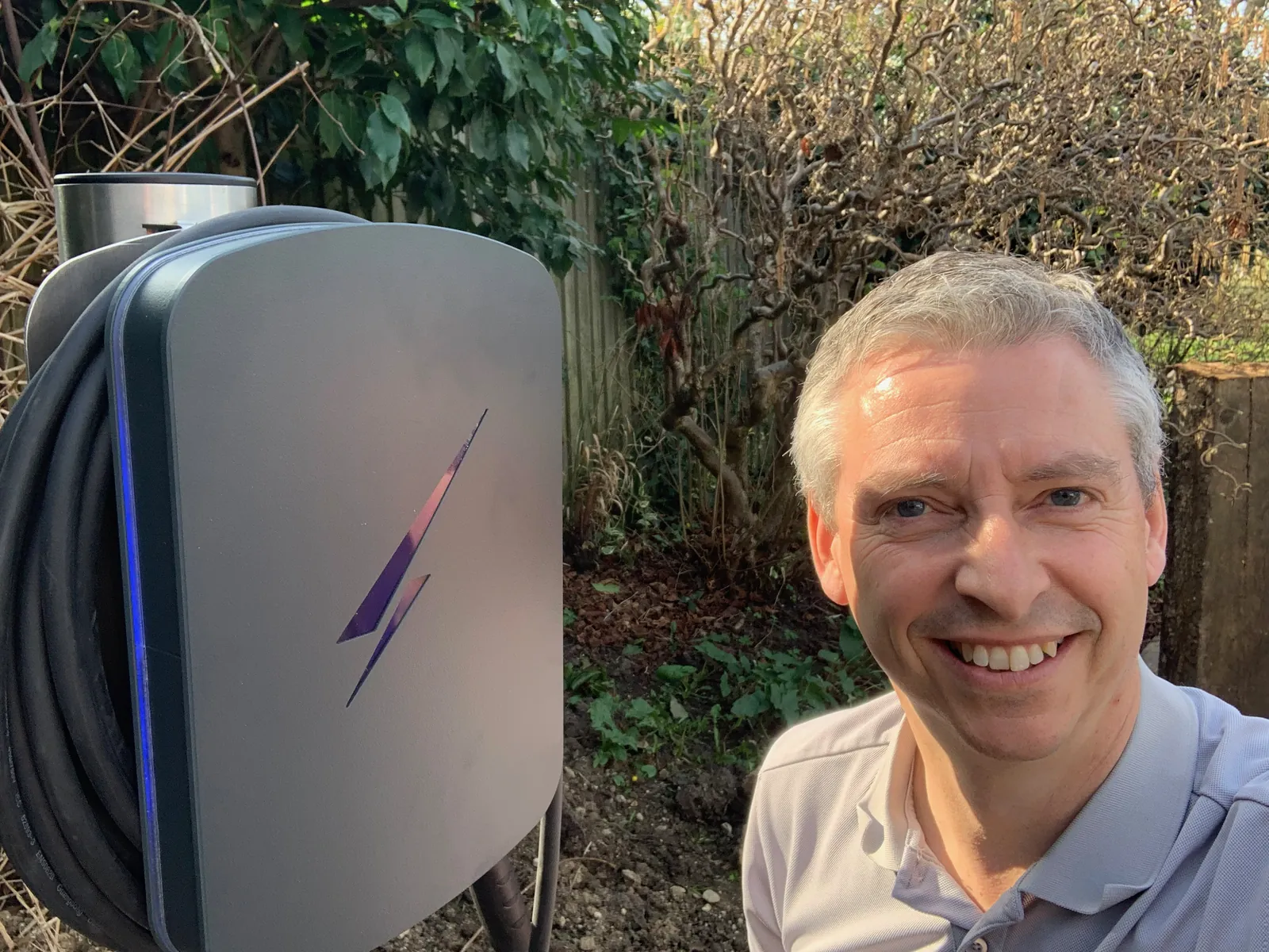 Jason Pope of Selec Group beside a post mounted EV charger he fitted in a garden