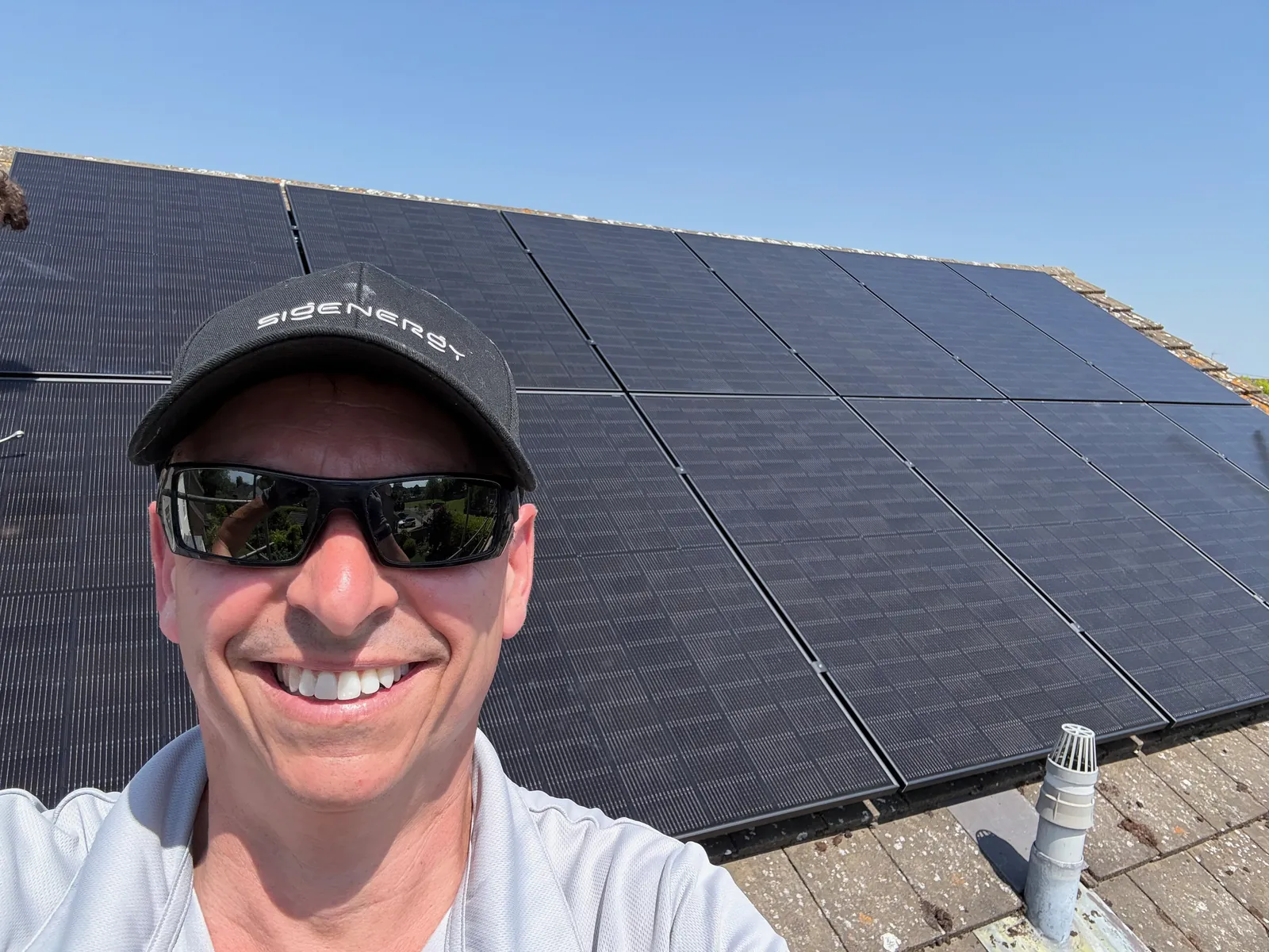 Jason Pope of Selec Group on a roof beside newly fitted solar panels in Grafham