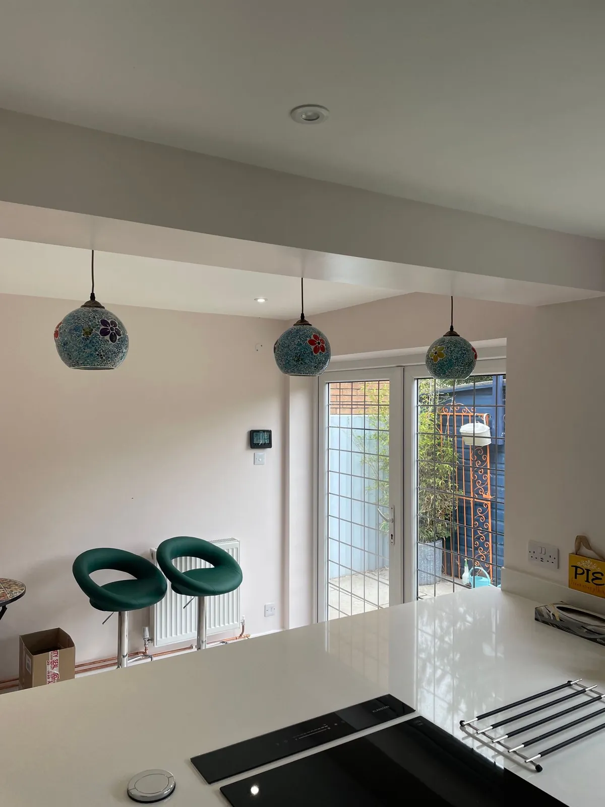 Three mosaic glass pendant lights over a kitchen island, fitted by Selec Group