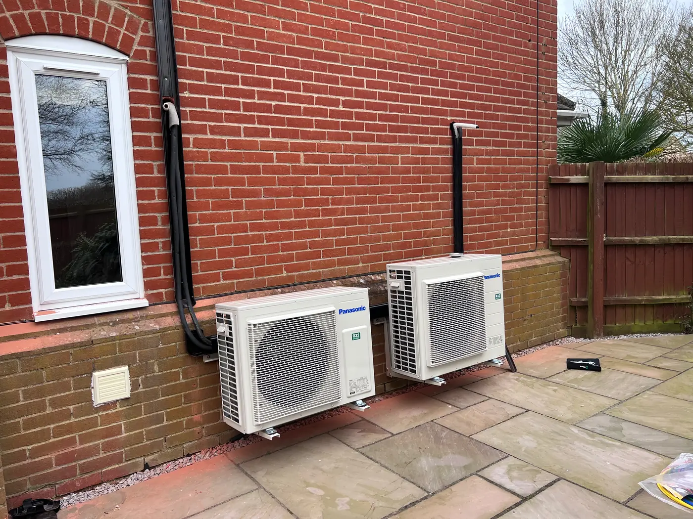 Two air conditioning outdoor units side by side on a patio in Stow Longa, Selec Group install