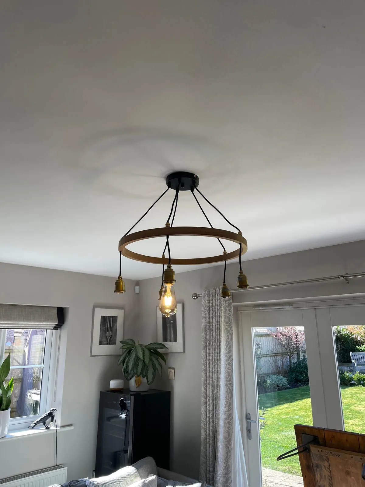 Black wagon wheel chandelier in a dining room, fitted by Selec Group